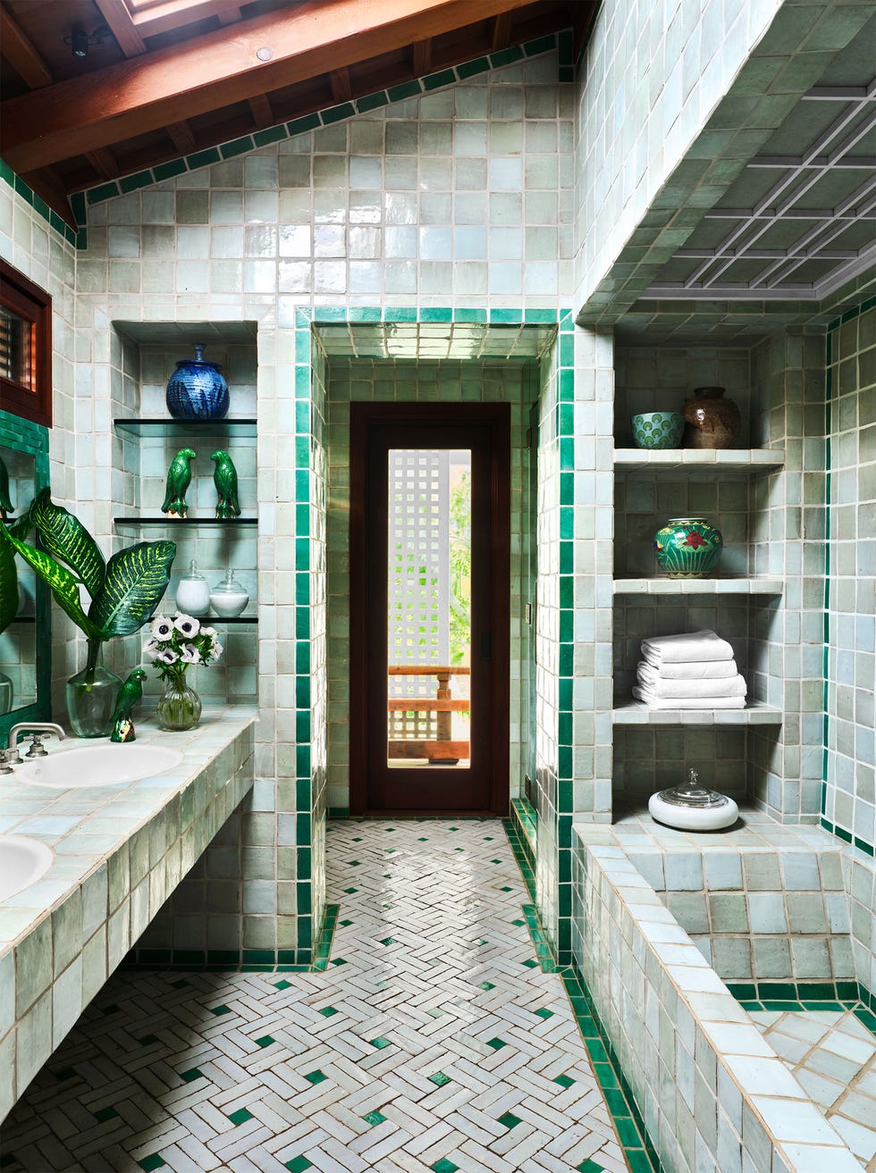 guest bathroom with lots of green tiling, inset shower shelf niche, plants, and more