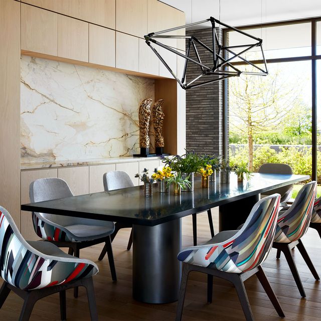 black double pedestal block table with colorful abstract potato chip chairs pulled up to it