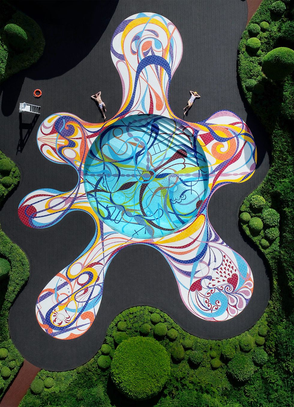 An overhead view of the colorful, curvaceous pool and the amorphous mass extending from it.