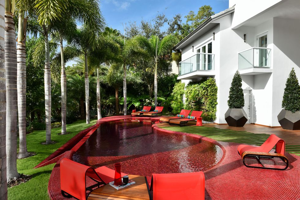in ground kidney shaped pool in red with all furniture also in red