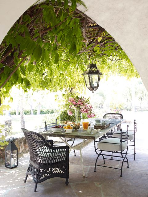 Une lanterne suspendue antique, des chaises en osier et des chaises en fer antiques sur le porche
