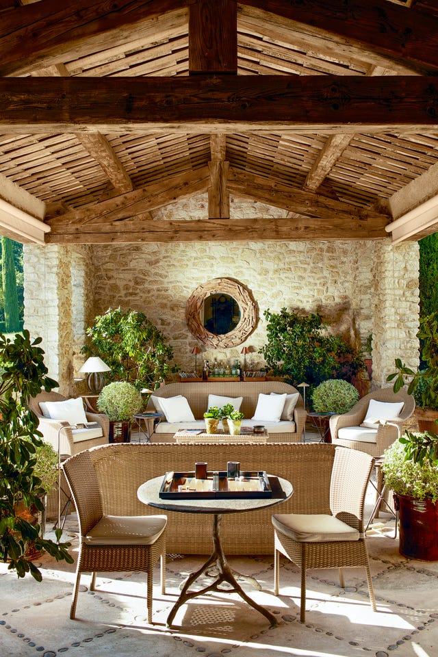outdoor living room with beamed ceiling, wicker furniture and large mirror