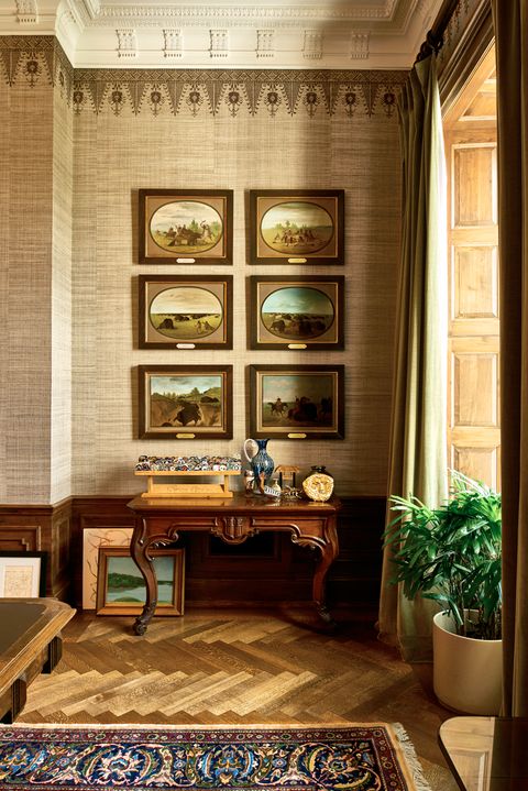 wall with a grouping of prints over a desk