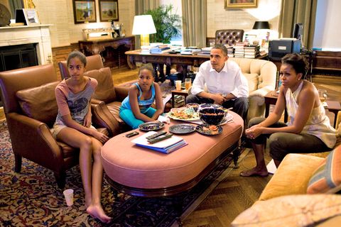 president barack obama, first lady michelle obama, and their daughters malia and sasha sit watching television