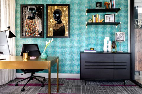 office with light blue tiled walls and two gold fleck pieces of art hanging over the desk