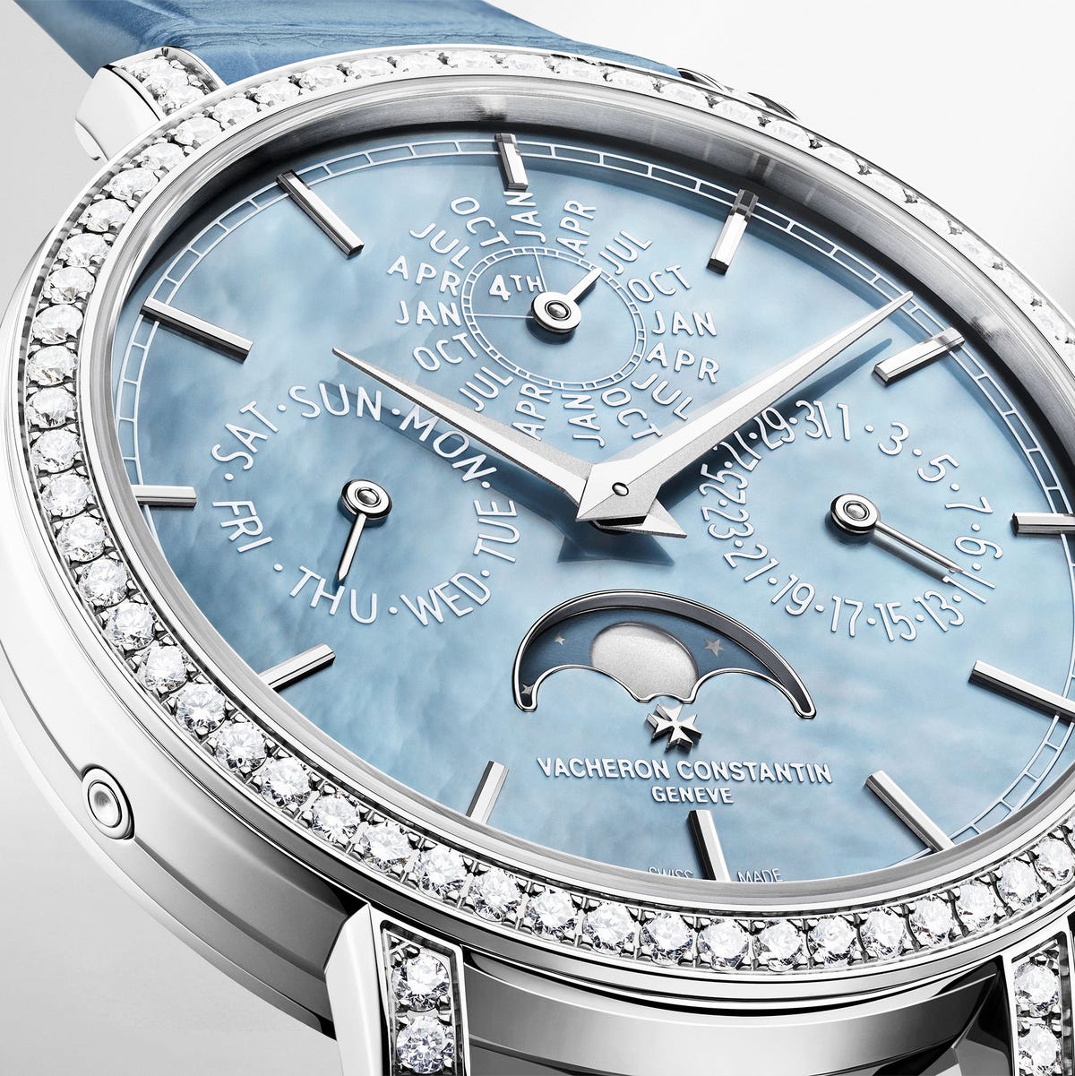 expensive looking wrist watch with a blue face in white gold surrounded by diamonds