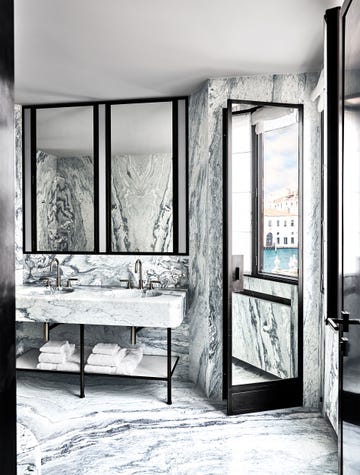 a black and white marble bathroom with a large mirror and double vanity