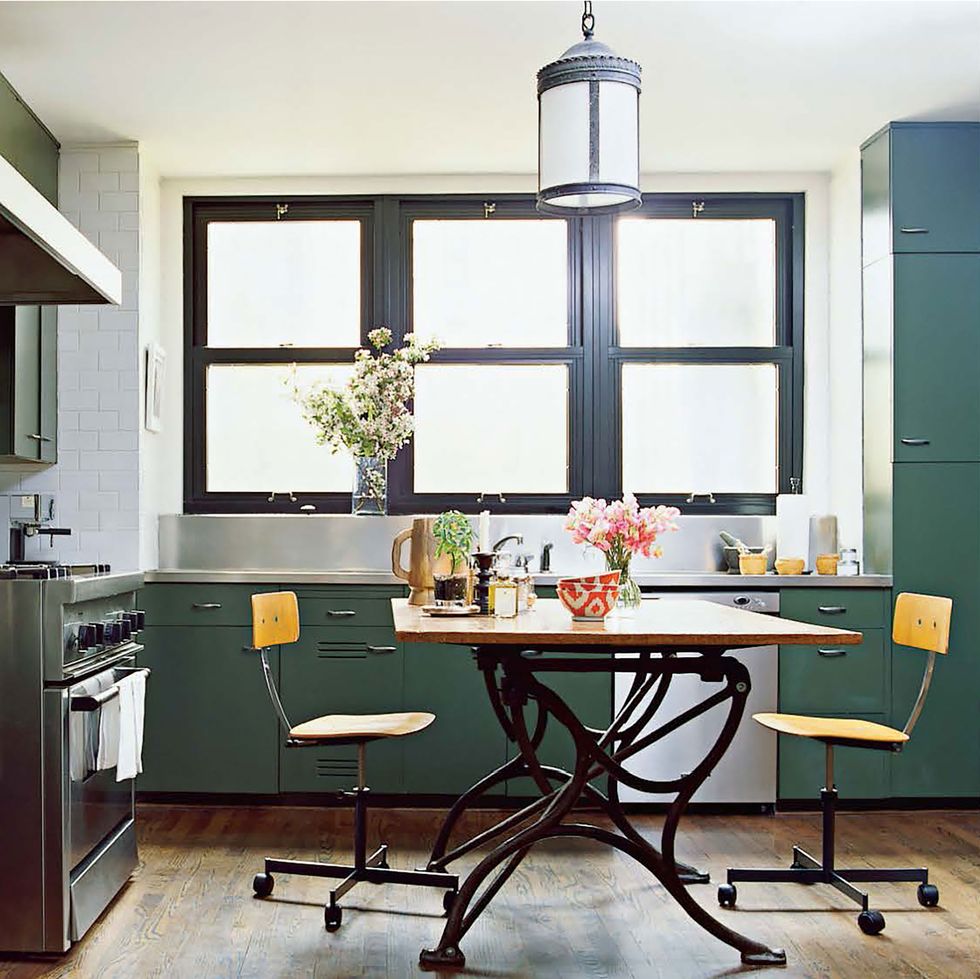 in the kitchen a 19th century architect s table and 1950s school chairs the range is by viking and the metal cabinets are original