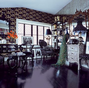 sui’s collection of busts by gemma taccogna is displayed in the study alongside furniture painted glossy black the walls are covered in a chinoiserie paper by stark and antiqued mirror and a taxidermy peacock from the evolution store sits atop an inlaid chest from abc carpet and home