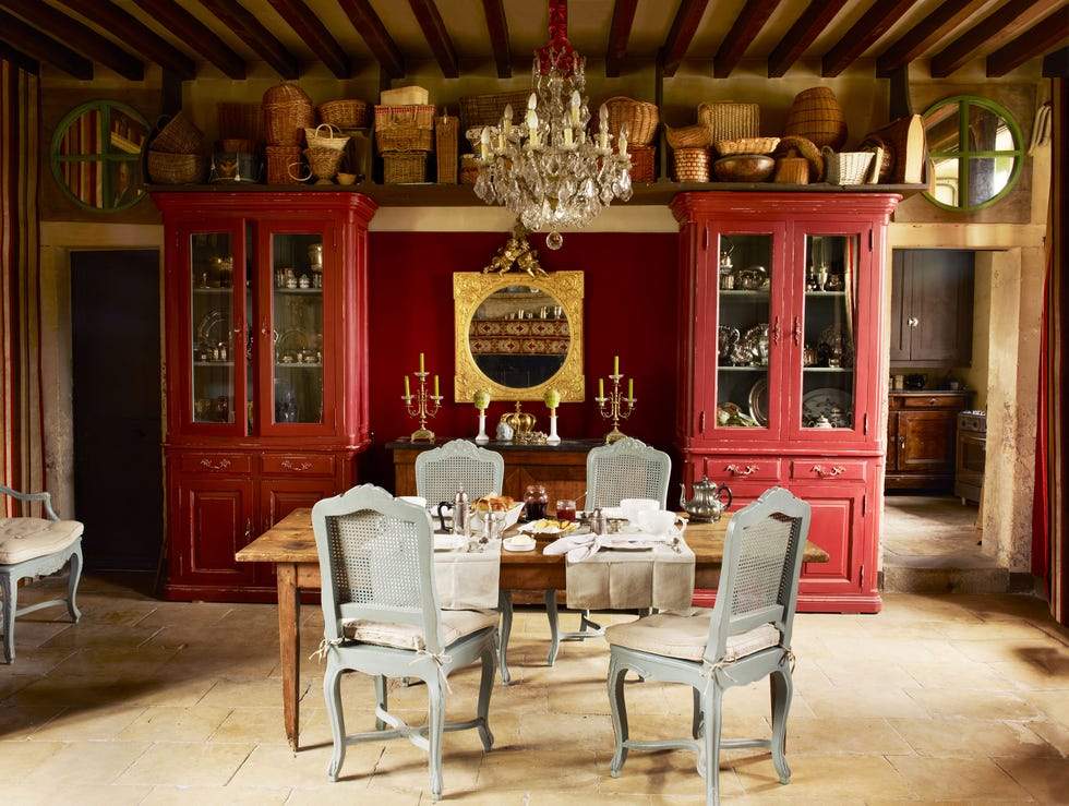 dining area featuring a wooden table elegant chairs and a large wall size decorative red cabinet at back