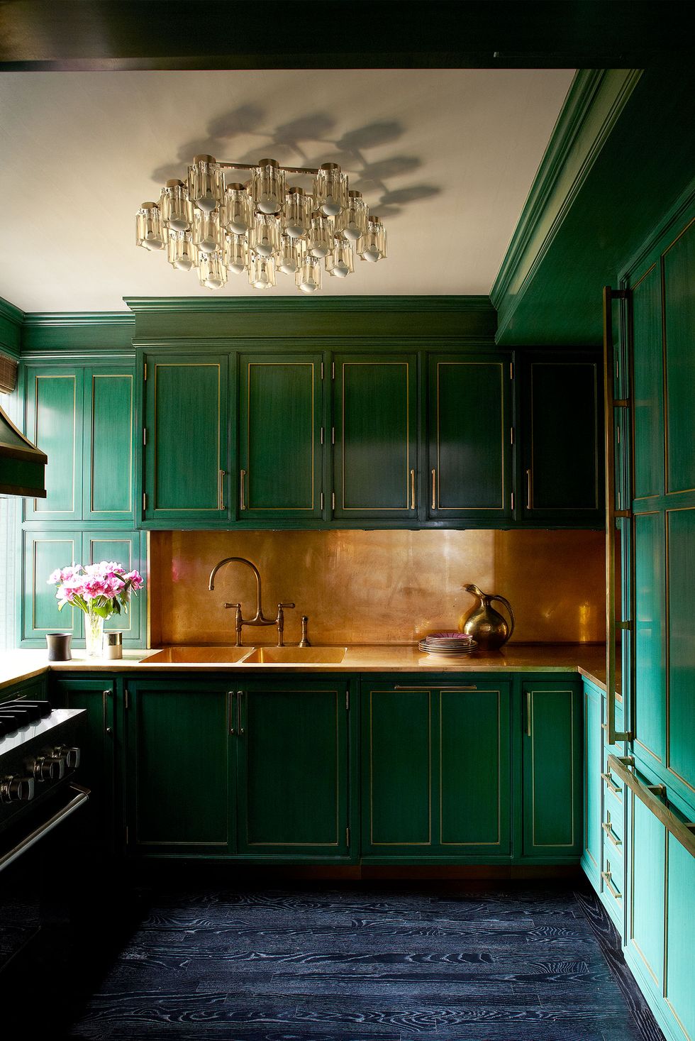 very green galley kitchen with brass fittings and a blue wood floor and gold backsplash