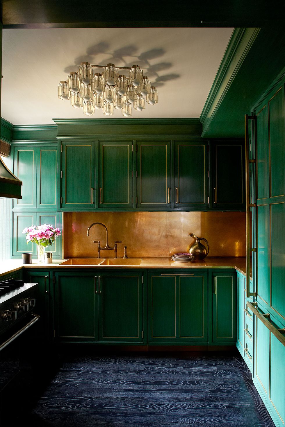 very green galley kitchen with brass fittings and a blue wood floor and gold backsplash
