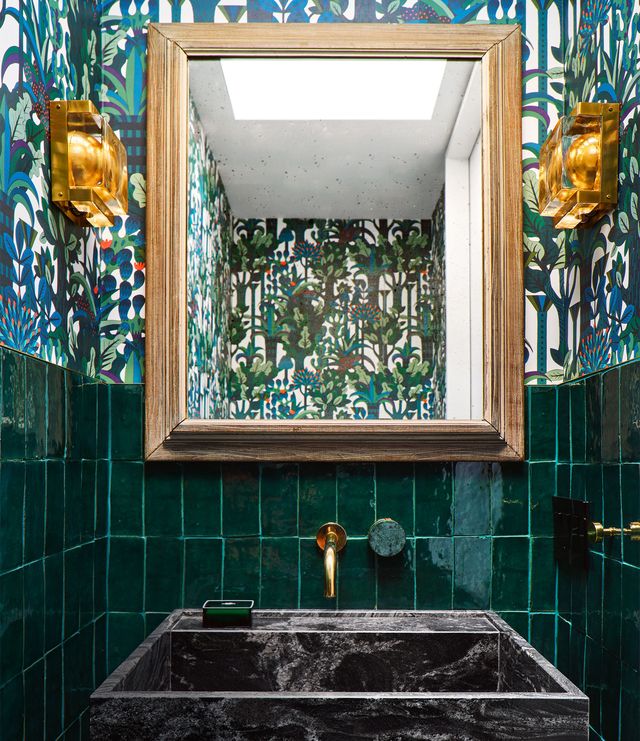 green half tiled, half wallpapered bathroom with square stone looking sink