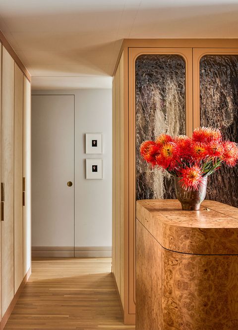 all wooden closets with rounded counter to one side and a bouquet of lovely spiky red flowers in them