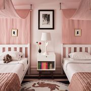 twin beds with a pink canopies and little framed silhouettes over them