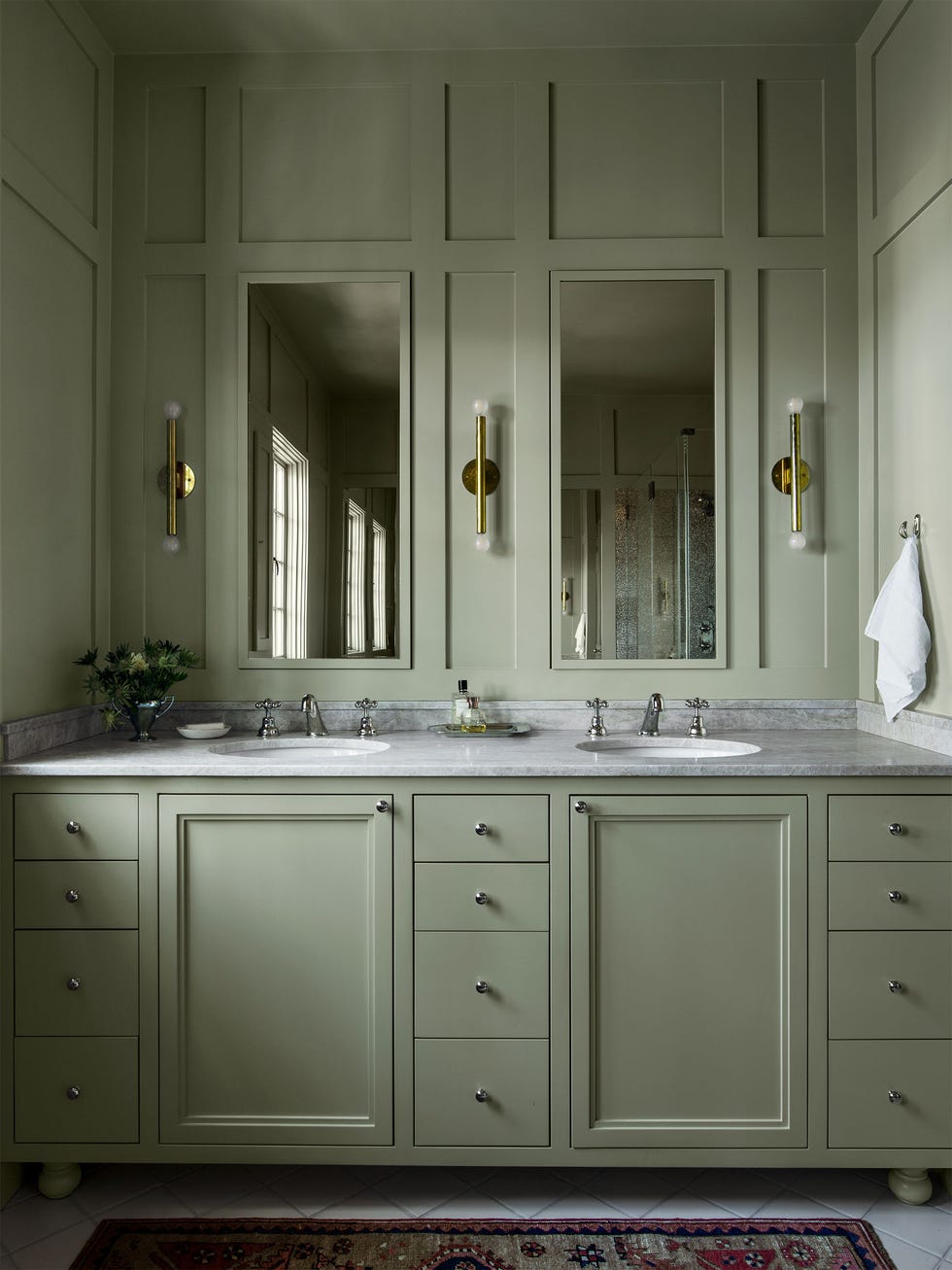 built in vanity in warm gray green tones with two sinks and two mirrors and sconces