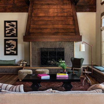 cozy living room with raised fireplace with tile and a very large wooden beam hood and wall surround