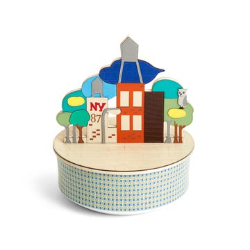 round patterned box with small stand up cutouts of city skyline with buildings and trees