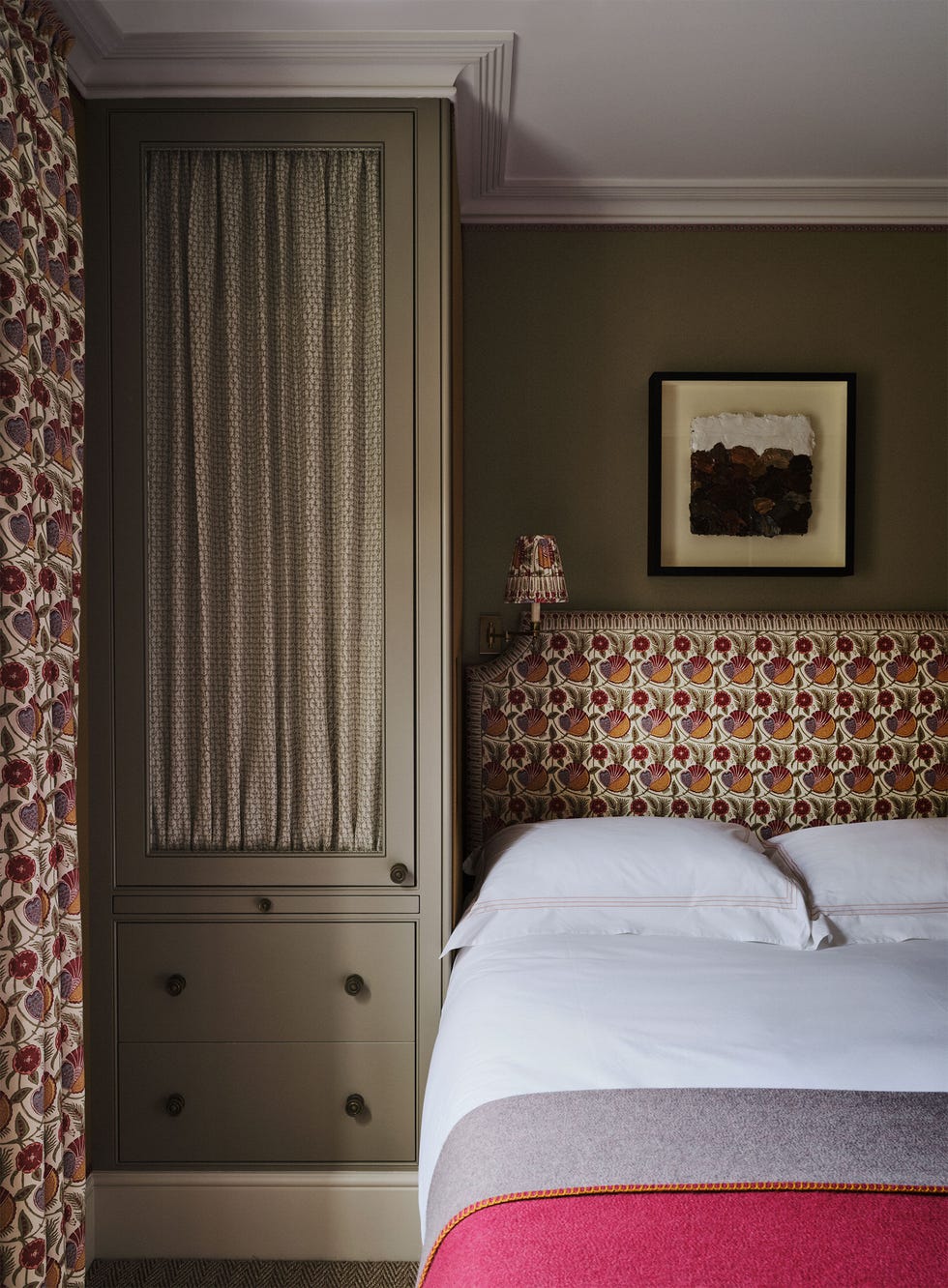Veere Grenney - ELLE DECOR a guest bedroom has matching fabric on the headboard sconce and curtains bed is dressed in white linens and a gray and ros