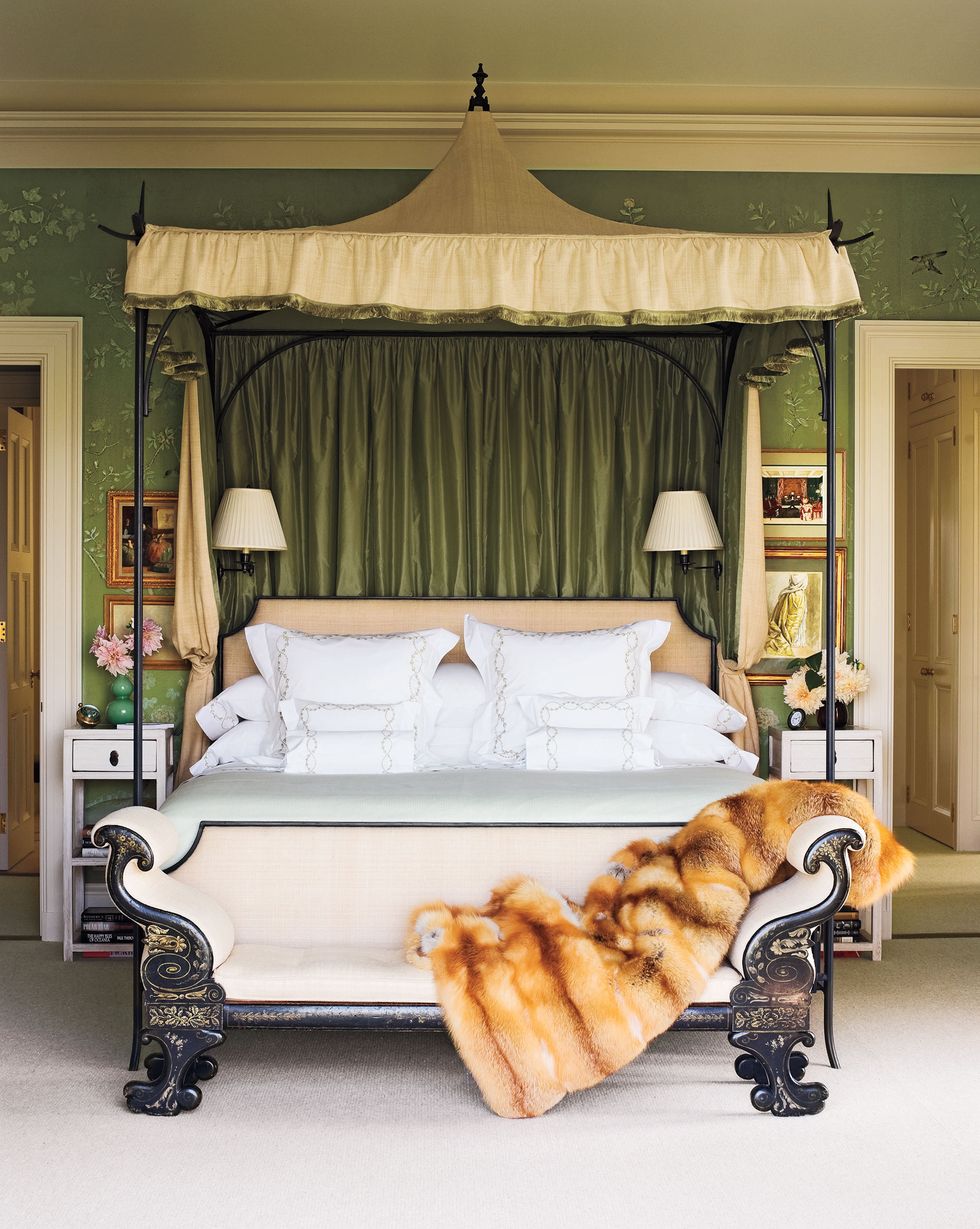 in the master bedroom the wrought iron bed by oscar de la renta is fitted with a canopy of silk by roger arlington designs the bedding is by e braun and co and the bench is 19th century