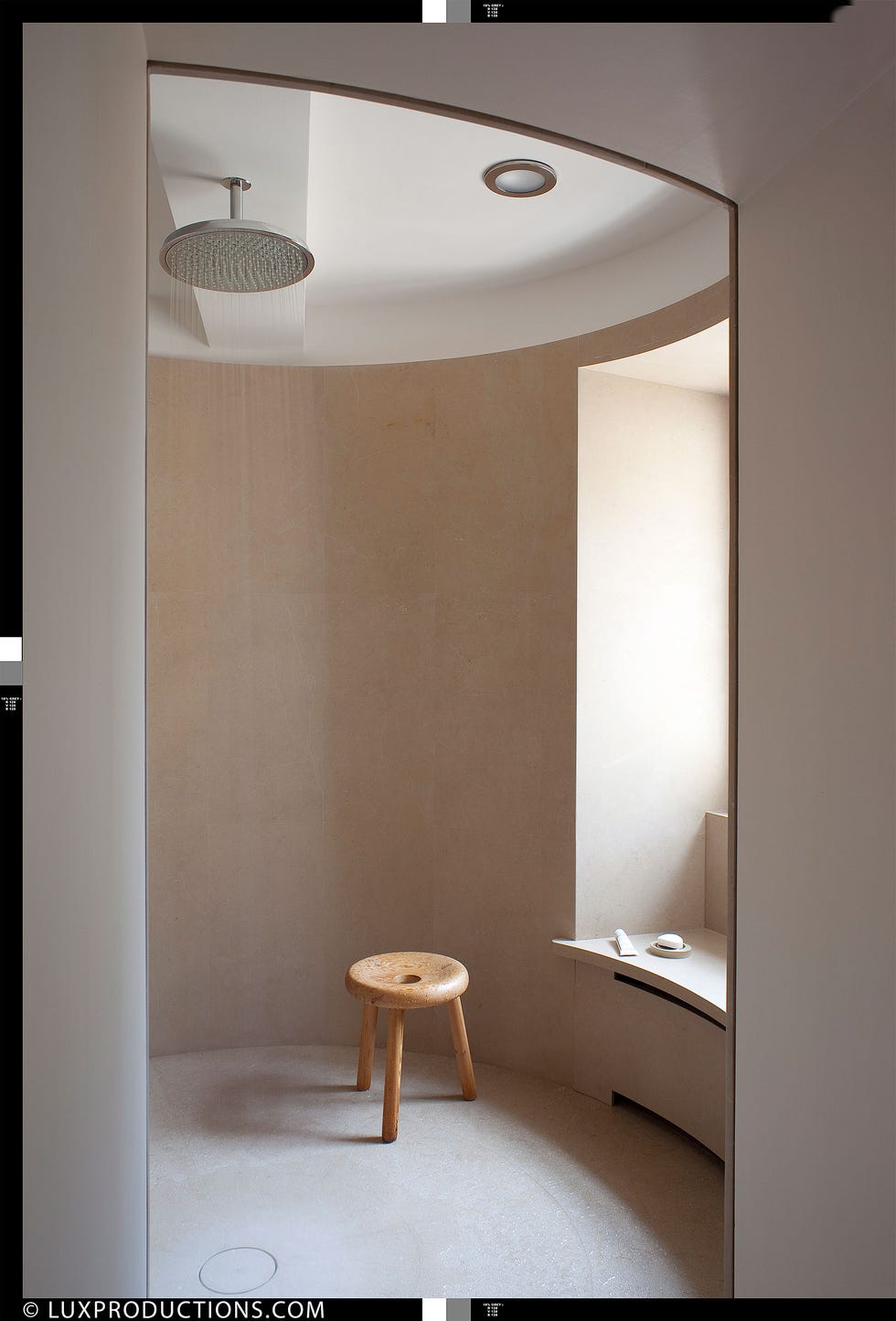 open rounded shower room with a three legged wood stool and window seat
