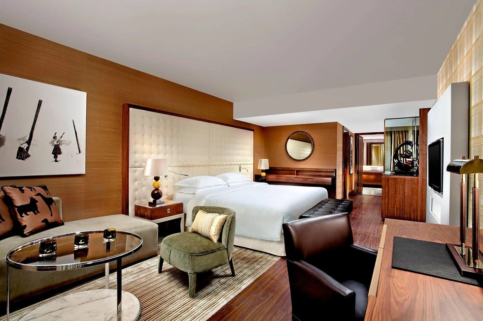 a bedroom with a large bed desk and seating area