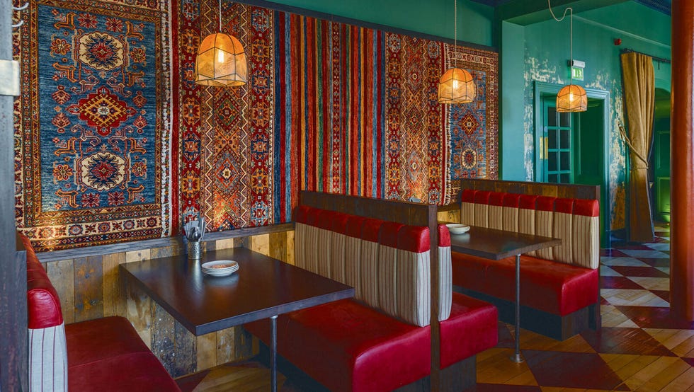 a room with red chairs and textiles on the walls at kimpton charlotte square hotel