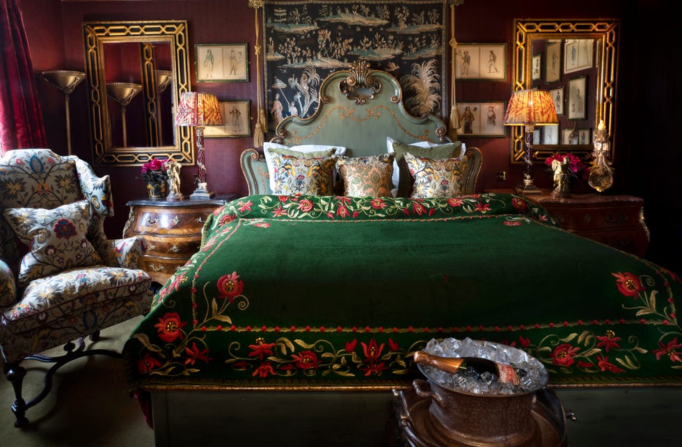 a bed with luxury bedding between two mirrors at prestonfield house