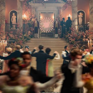 a group of people dancing at a ball in a large room