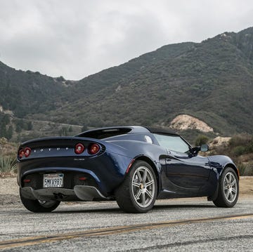 a black sports car on a road with mountains in the background