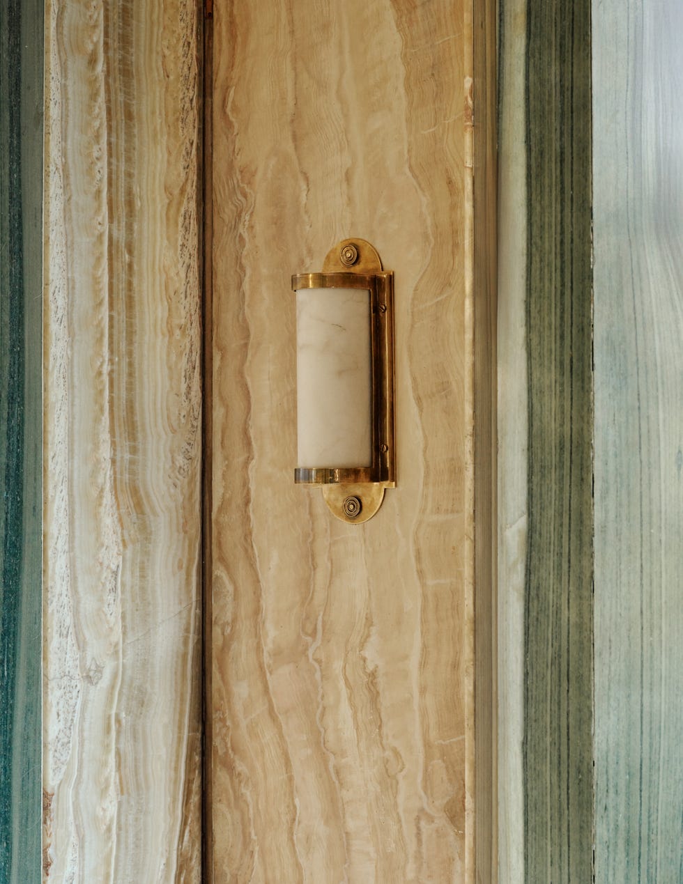 A wall sconce mounted on textured surfaces.