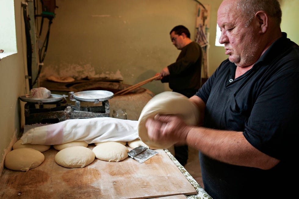 Samen met zijn zoon bakt een bakker uit het plaatsje Mestia tonis puribroden
