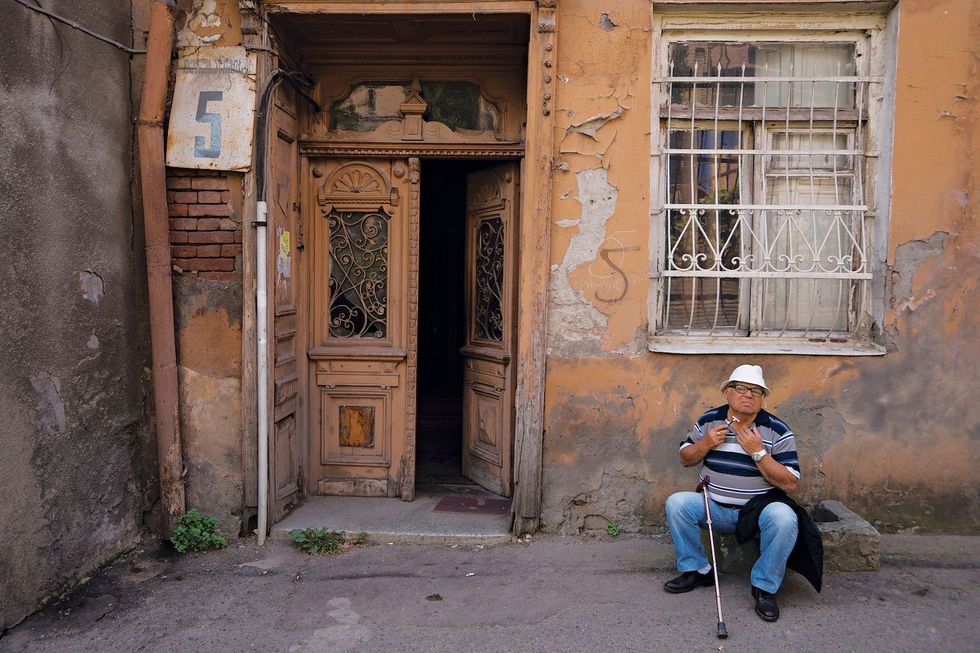 In de Lado Asatianistraat in de joodse wijk van Tbilisi scheert een man zich buiten