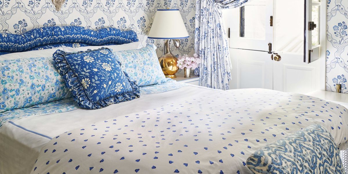 a blue and white bedroom with a custom headboard 
and bed skirt  with lots of pattern