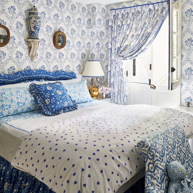 a blue and white bedroom with a custom headboard 
and bed skirt  with lots of pattern