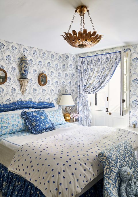 a blue and white bedroom with a custom headboard 
and bed skirt  with lots of pattern