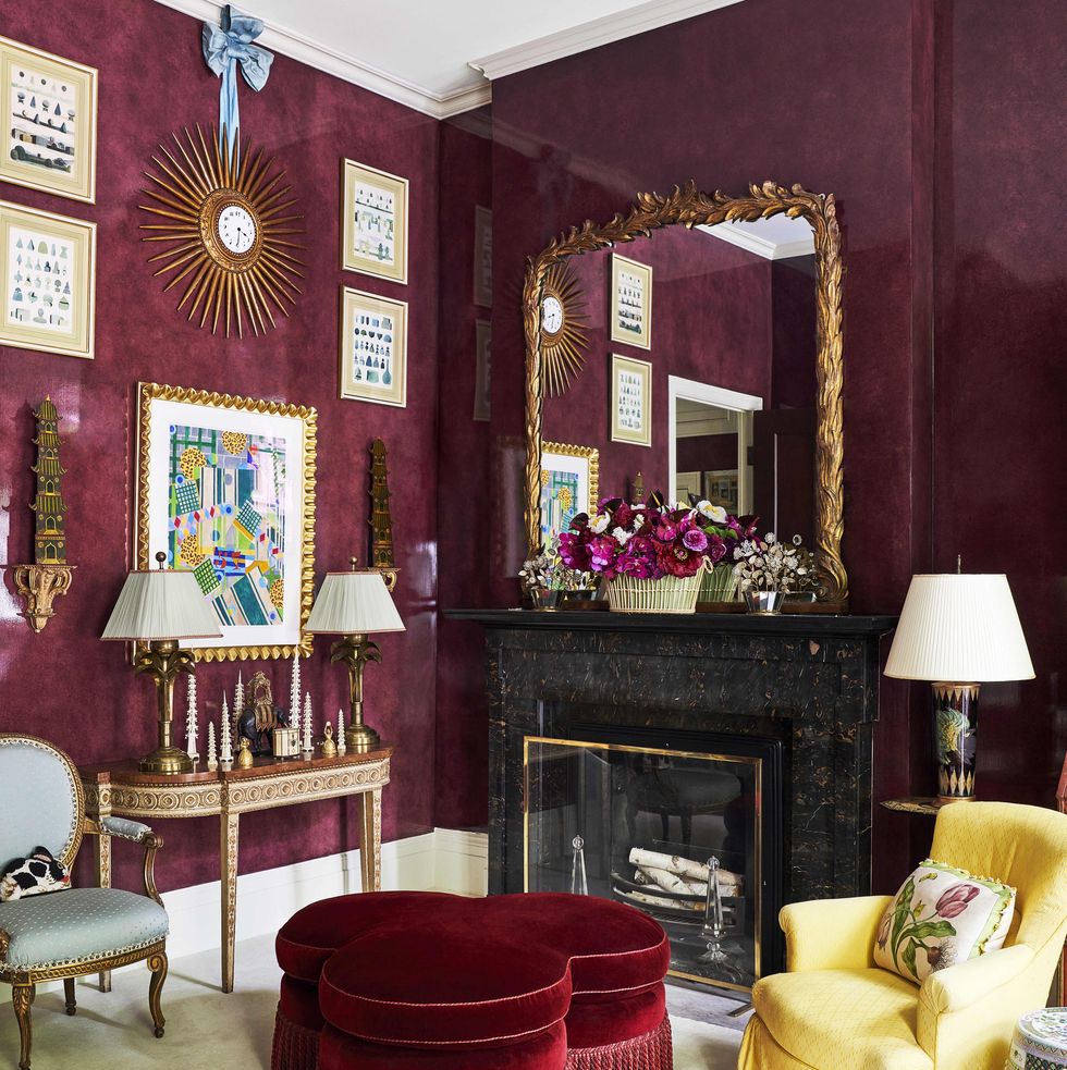 a 19th century french sunburst clock is suspended by a shantung silk bow from mario buattas living room and a velvet ottoman is on the floor in the aubergine walled room