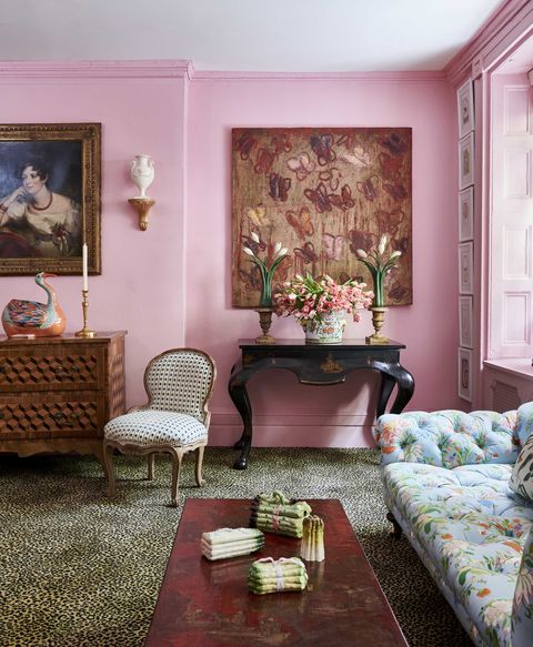 pink walls and leopard print carpet in a room with a floral tufted sofa