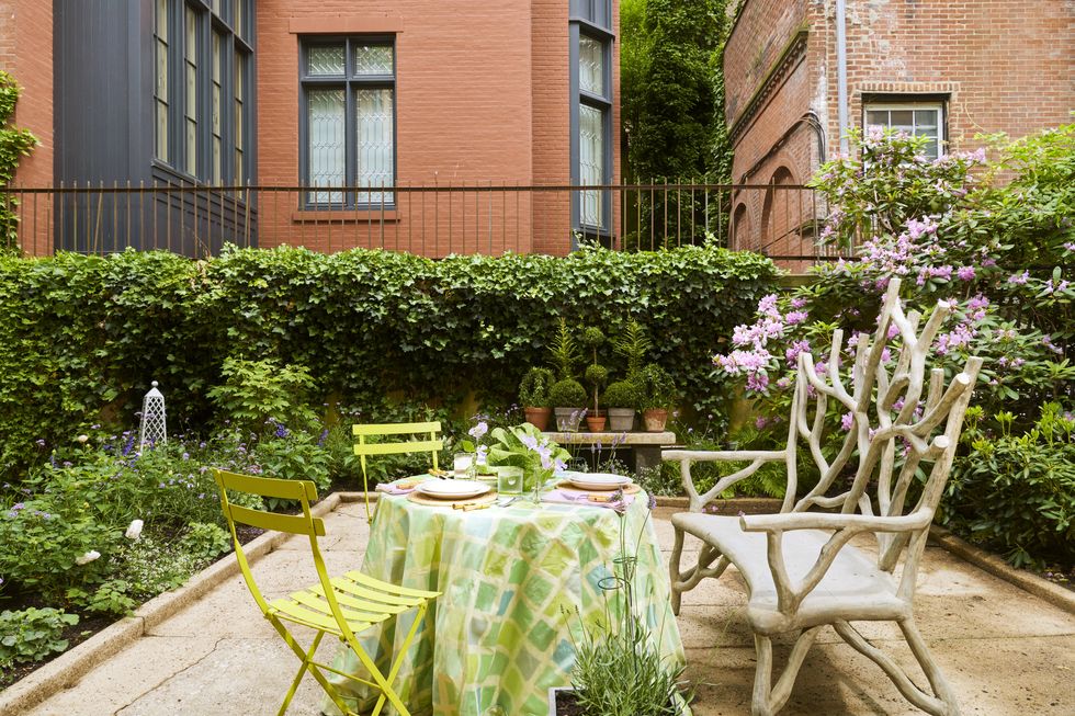 in the upper garden a faux bois bench is paired with slatted metal bistro chairs
