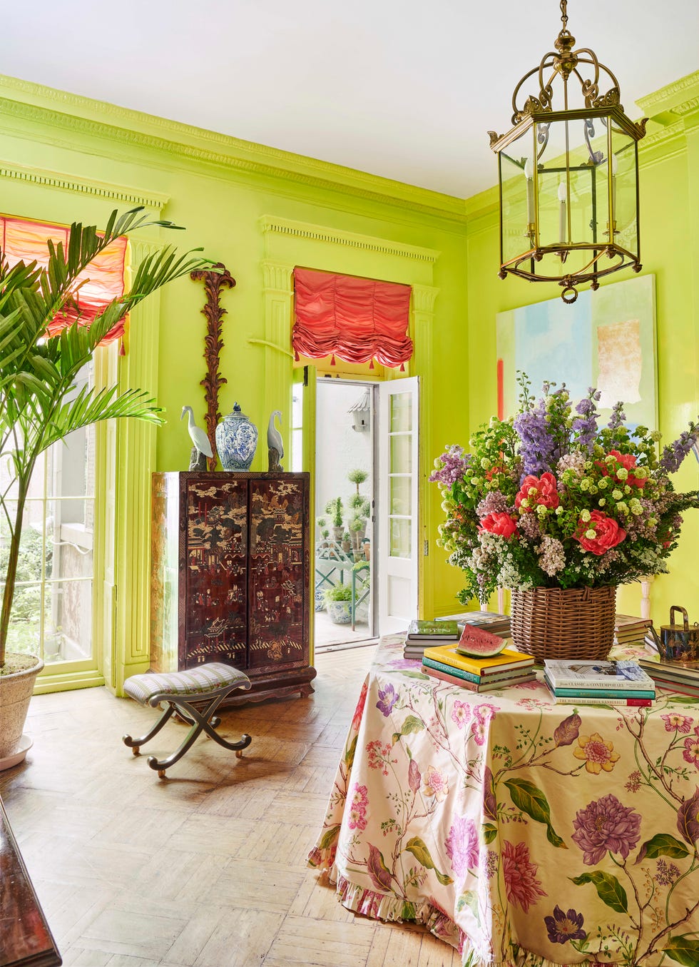 the upper salon is lime green with an octagonal table in the middle skirted in a floral tablecloth