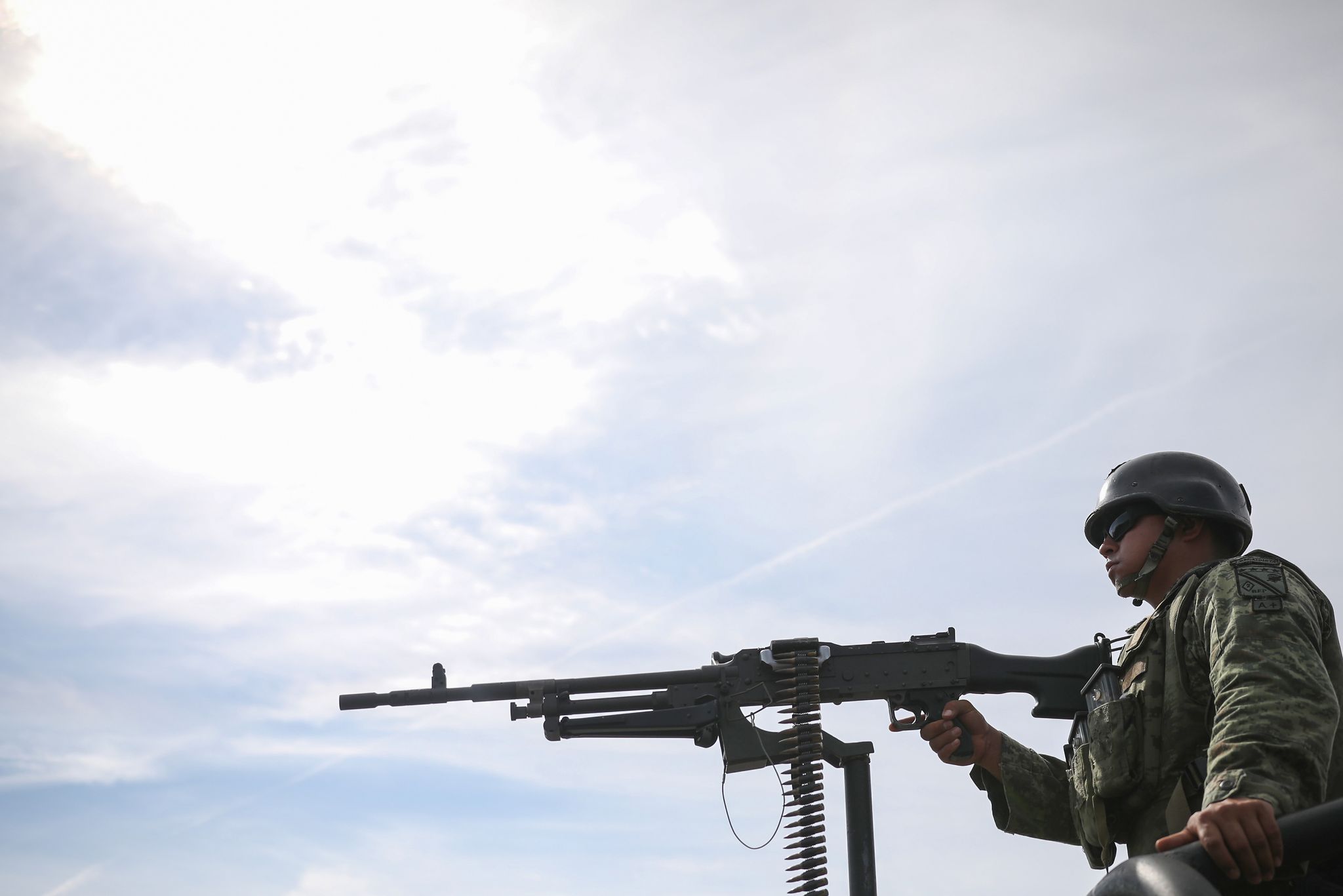 a solider mans a truck mounted machine gun at a checkpoint on the outskirts of culiacán
