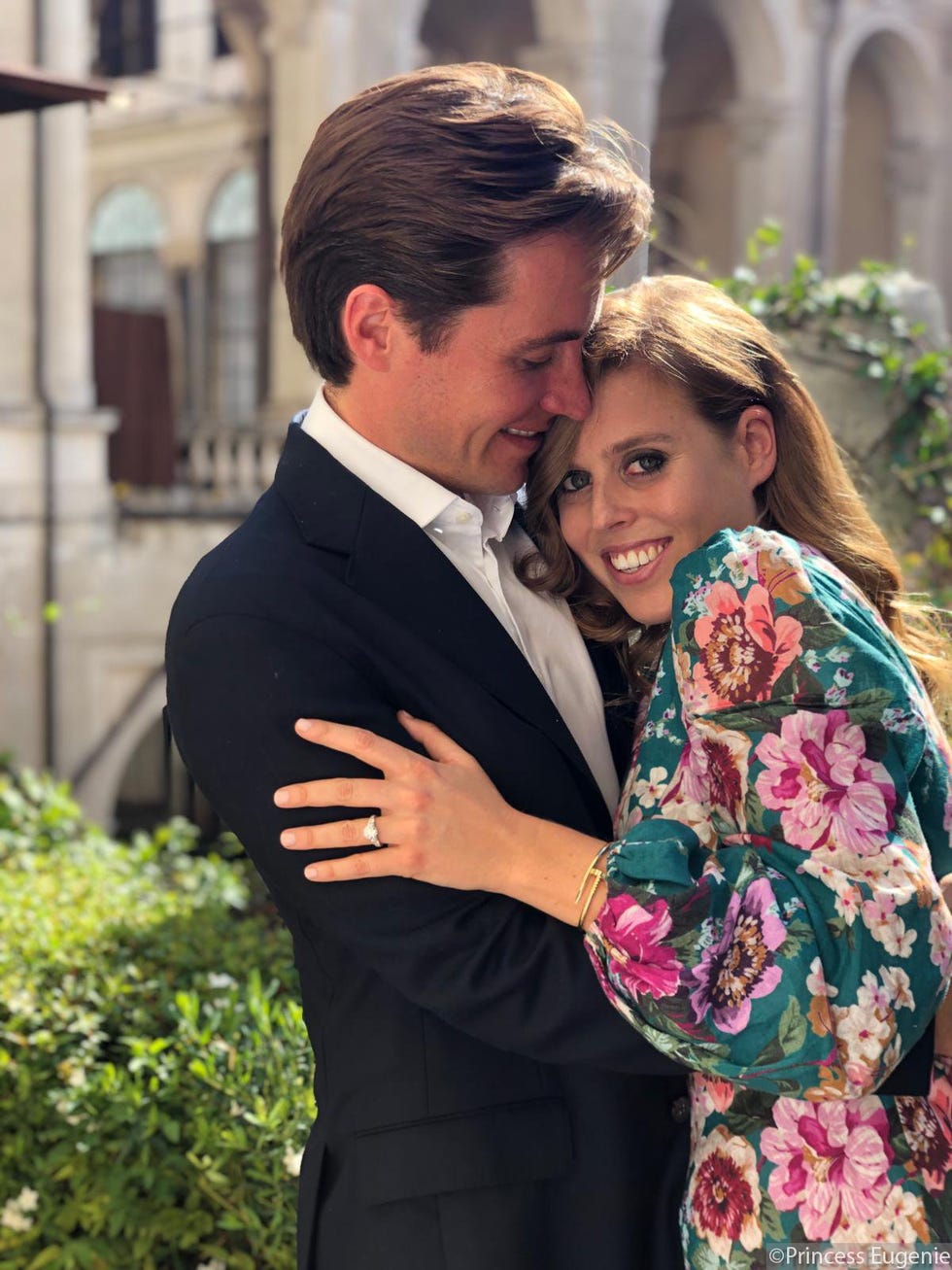 couple embracing in an outdoor setting with greenery