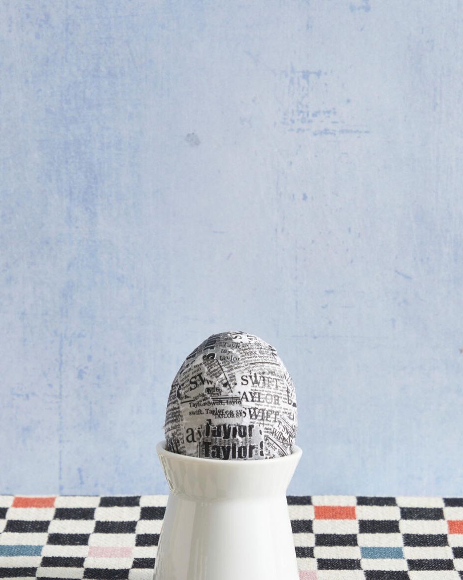 easter egg decorated to look like a taylor swift album cover in an egg cup