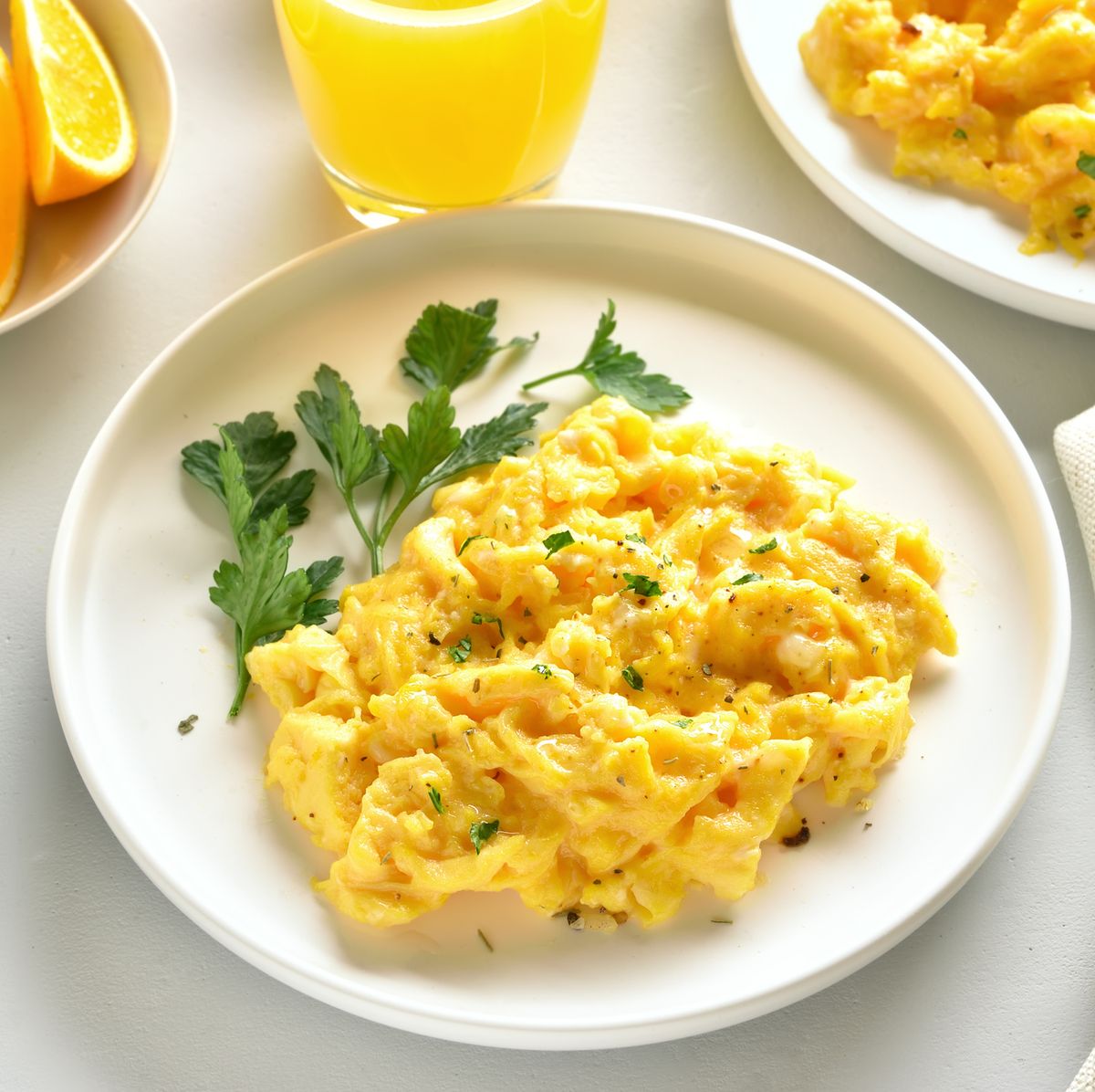 a plate of scrambled whole eggs peppered with fresh chives