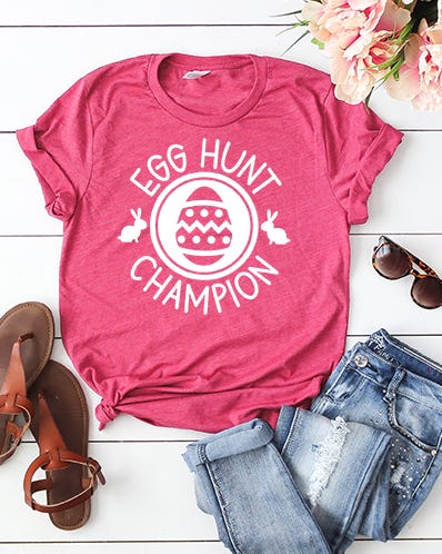 egg hunt t shirt casual outfit featuring a pink tshirt with egg hunt champion design denim shorts sandals and sunglasses