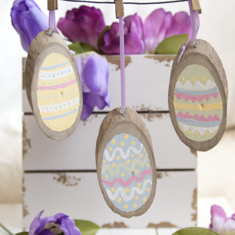 easter egg hunt ideas, painted wood slice easter eggs hanging from clothes pins