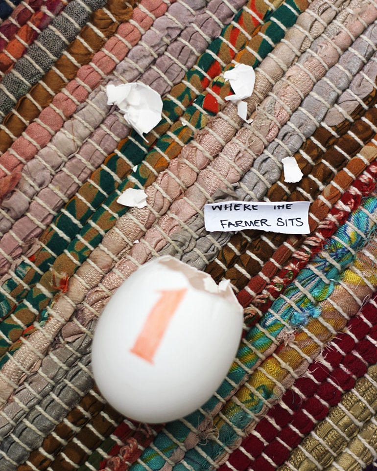 blown out egg hunt cracked egg on a textured fabric surface with a note next to it