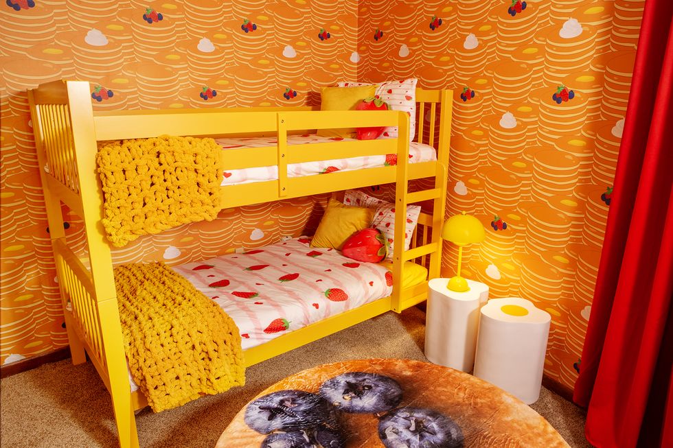 a baby crib with yellow and red blankets