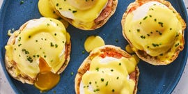 english muffins topped with ham, poached eggs and hollandaise on a plate