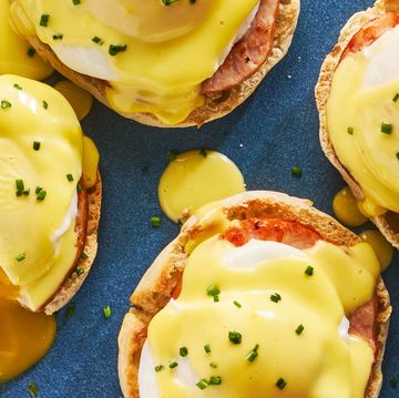 english muffins topped with ham, poached eggs and hollandaise on a plate